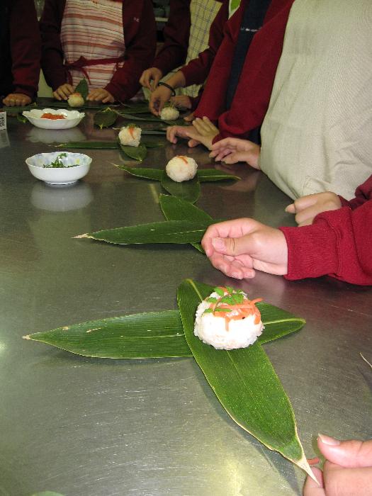 笹寿司づくりを楽しむイベント参加者の写真